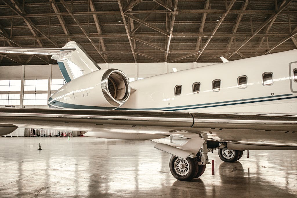 A sleek private jet with visible engine inside a spacious hangar in Paris, France.